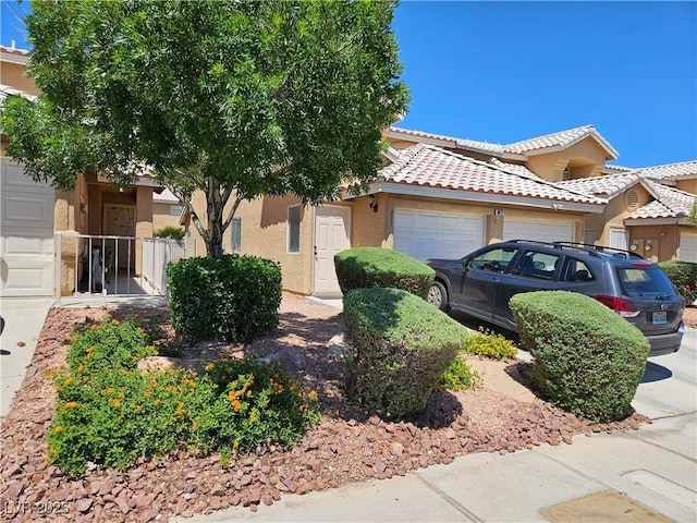 view of front of house with an attached garage, stucco siding, and a tile roof