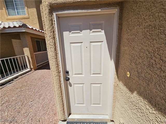 entrance to property with stucco siding