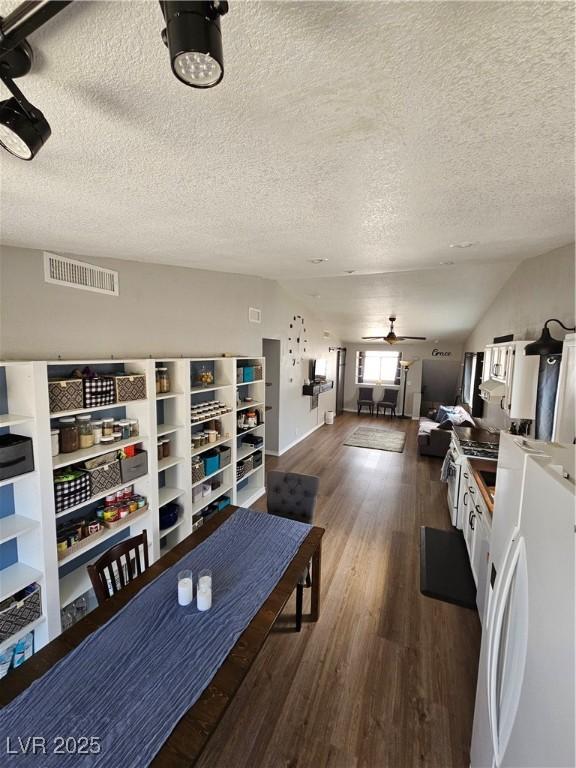 living room with wood finished floors, a ceiling fan, and a textured ceiling