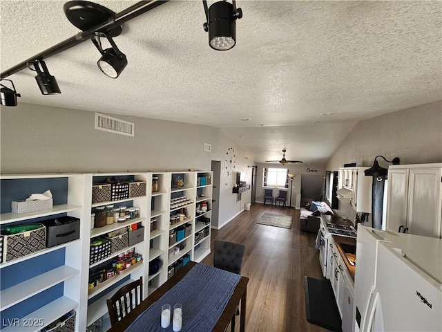 kitchen featuring dark wood-type flooring, lofted ceiling, a textured ceiling, a ceiling fan, and white range with gas cooktop