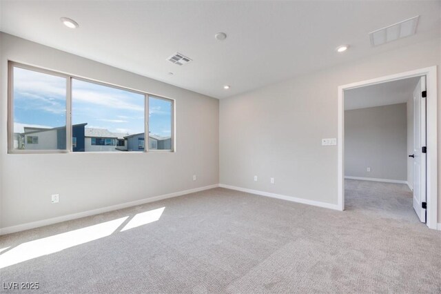 carpeted spare room featuring baseboards and recessed lighting