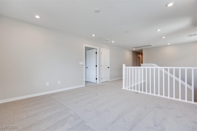 unfurnished room featuring light carpet, recessed lighting, and baseboards