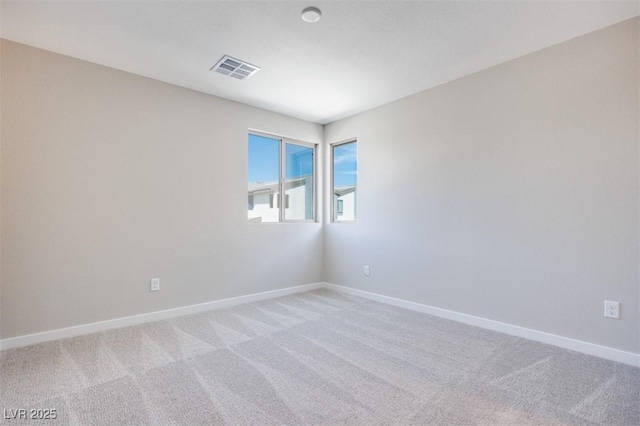 unfurnished room featuring light colored carpet and baseboards