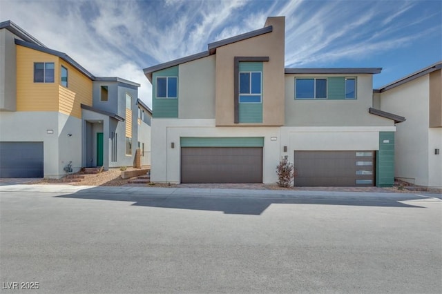 townhome / multi-family property with an attached garage and stucco siding