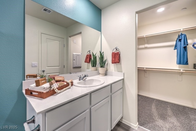 bathroom featuring vanity and a walk in closet