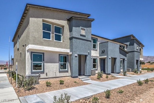 view of front of property featuring central AC unit and stucco siding