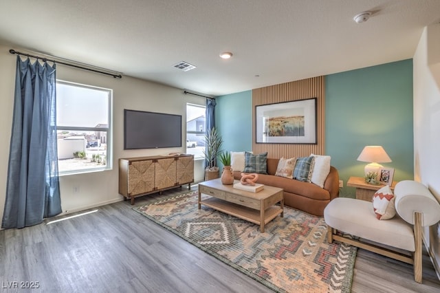 living area with wood finished floors, baseboards, and recessed lighting