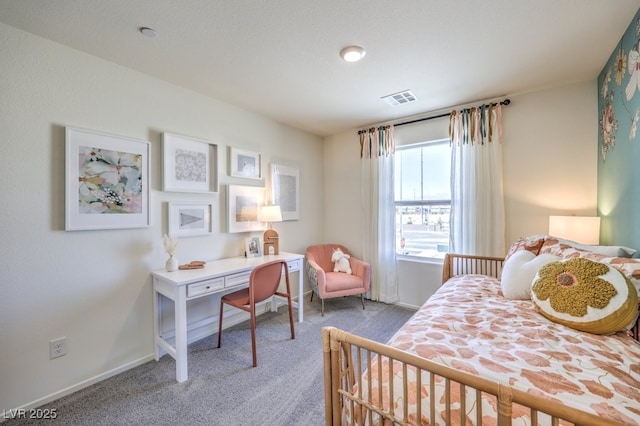 carpeted bedroom featuring an office area and baseboards