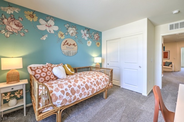 carpeted bedroom featuring a closet and baseboards