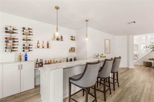 9615 Sedona Hills Ct, Las Vegas, NV 89147 - indoor bar featuring light wood-style flooring, pendant lighting, and stairs