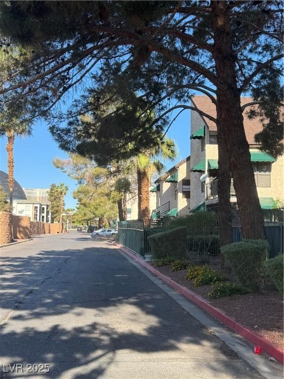 view of asphalt road featuring curbs