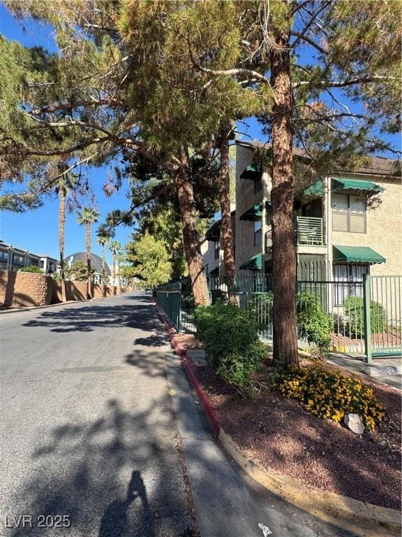 view of asphalt street with curbs