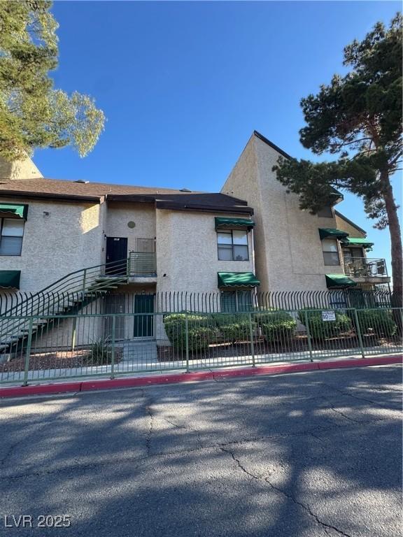 view of front facade featuring fence and stucco siding