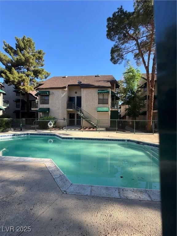 community pool with fence and a patio