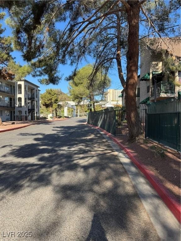 view of asphalt street with curbs, sidewalks, and a residential view