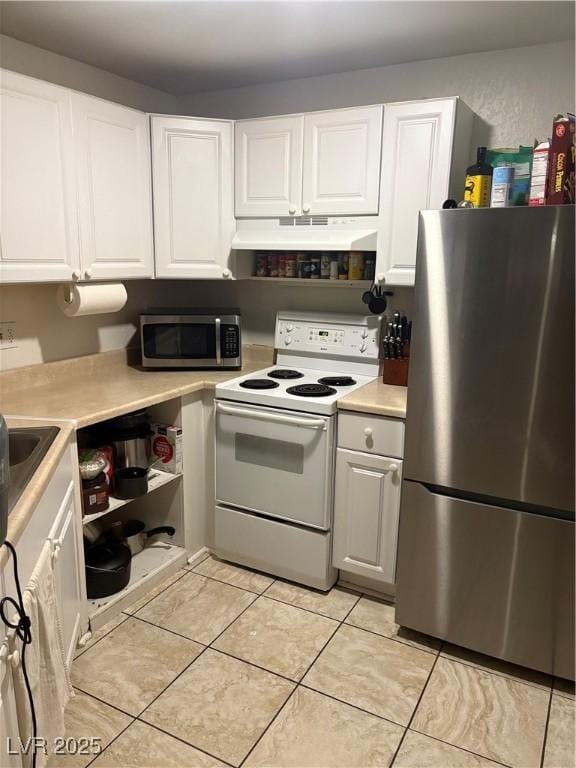 kitchen with appliances with stainless steel finishes, white cabinetry, light countertops, under cabinet range hood, and light tile patterned flooring