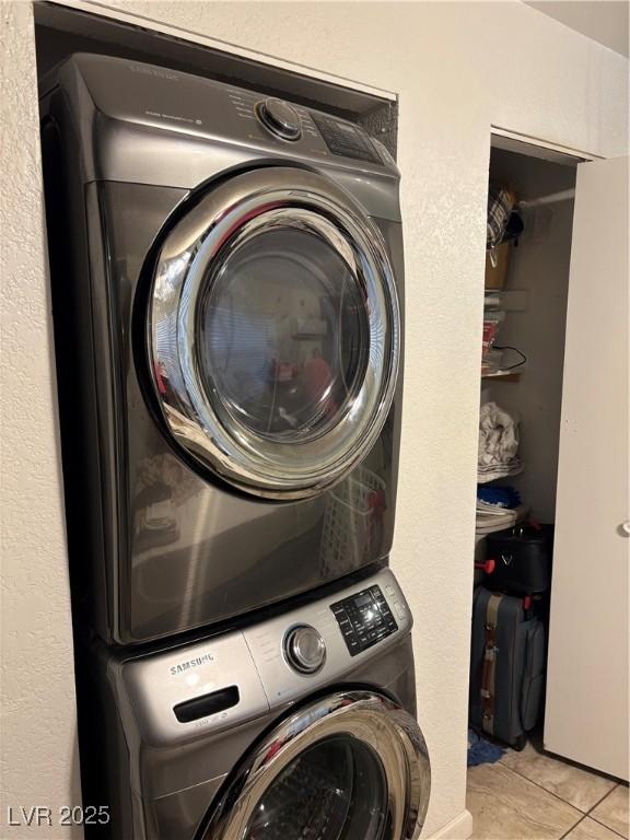 clothes washing area featuring stacked washer / dryer and light tile patterned floors