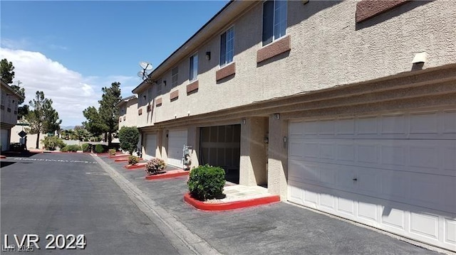 view of asphalt street featuring curbs