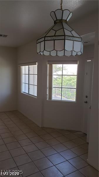 unfurnished dining area featuring light tile patterned floors and plenty of natural light