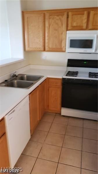 kitchen featuring white appliances, a sink, light tile patterned floors, and light countertops