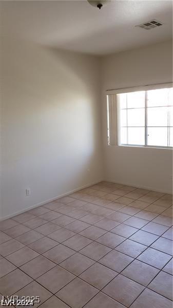 unfurnished room with light tile patterned floors and baseboards
