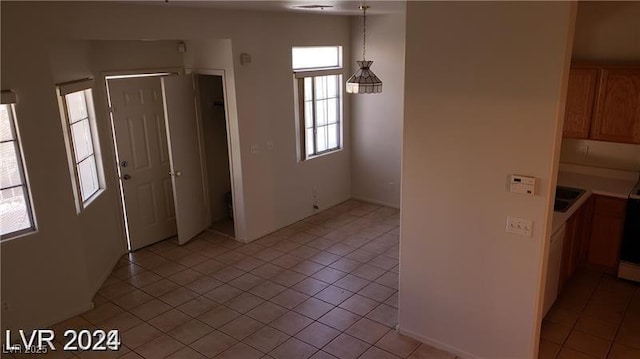 unfurnished dining area with plenty of natural light, light tile patterned flooring, and a sink