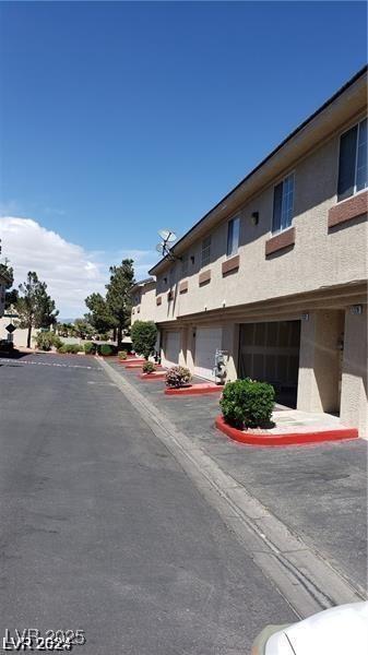 view of asphalt street with curbs