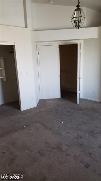 unfurnished bedroom featuring dark carpet and a closet