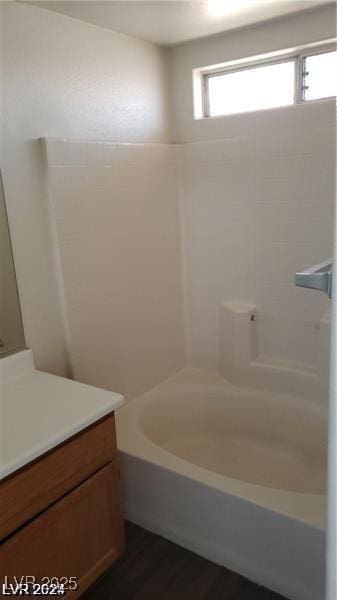 bathroom with vanity, wood finished floors, and washtub / shower combination