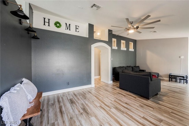 2860 Galena Peak Ln, Las Vegas, NV 89156 - living area with arched walkways, a ceiling fan, light wood-type flooring, and baseboards