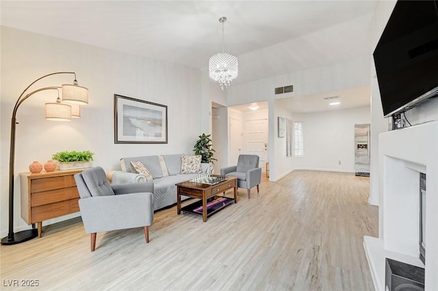 6771 Shelter Ln, Las Vegas, NV 89103 - living room with light wood-style floors, a chandelier, and baseboards