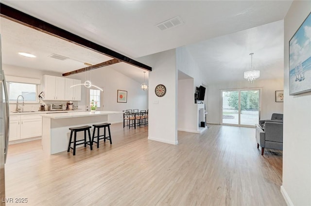 6771 Shelter Ln, Las Vegas, NV 89103 - living room with a chandelier, light wood finished floors, and baseboards