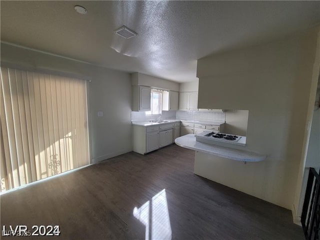 kitchen featuring white gas cooktop, white cabinetry, dark wood-style flooring, and light countertops