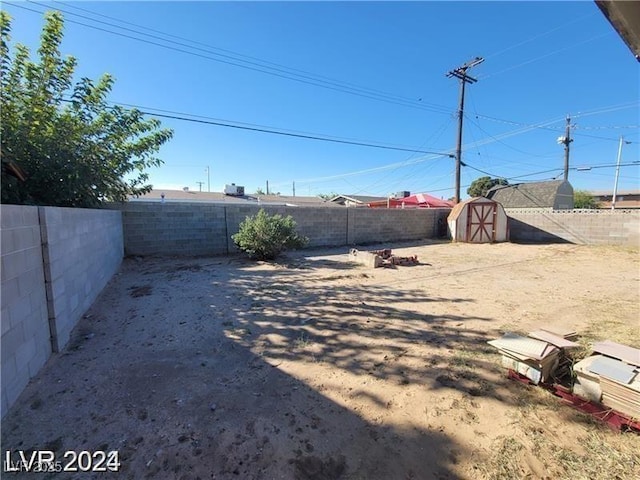 fenced backyard featuring a storage unit and an outdoor structure