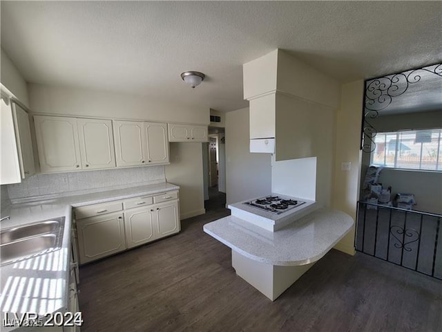 kitchen featuring a sink, white gas stovetop, white cabinets, dark wood-style floors, and a textured ceiling