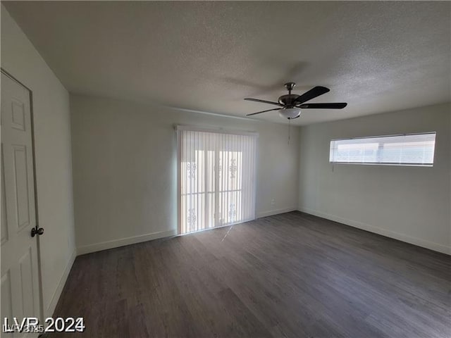 unfurnished room featuring a textured ceiling, dark wood-style flooring, baseboards, and ceiling fan