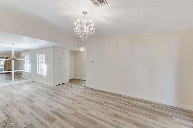 2633 S Durango Dr Unit 201, Las Vegas, NV 89117 - empty room with light wood-type flooring, a chandelier, baseboards, and a textured ceiling