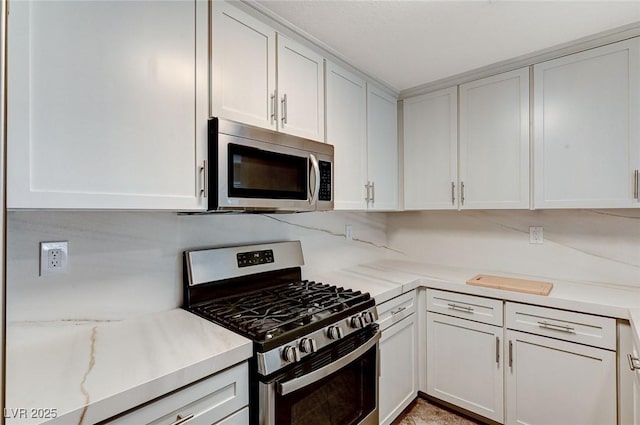 2633 S Durango Dr Unit 201, Las Vegas, NV 89117 - kitchen featuring stainless steel appliances, white cabinetry, and light stone counters
