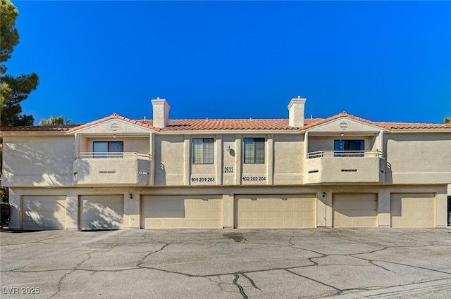 2633 S Durango Dr Unit 201, Las Vegas, NV 89117 - view of front of home with a chimney, stucco siding, and a balcony