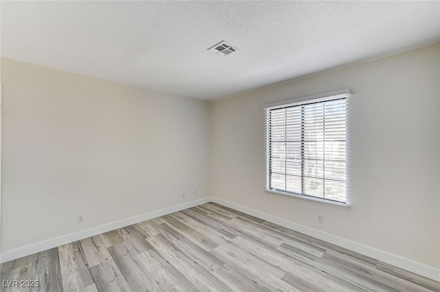 2633 S Durango Dr Unit 201, Las Vegas, NV 89117 - unfurnished room with light wood-style flooring, baseboards, and a textured ceiling