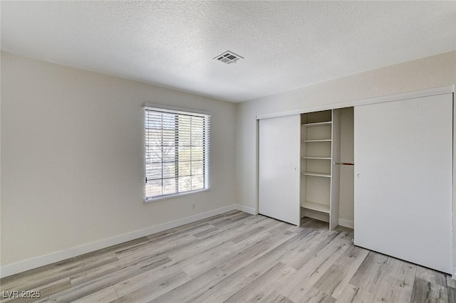2633 S Durango Dr Unit 201, Las Vegas, NV 89117 - unfurnished bedroom featuring light wood-style flooring, a closet, a textured ceiling, and baseboards