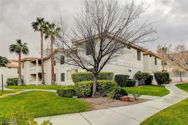 2633 S Durango Dr Unit 201, Las Vegas, NV 89117 - view of property exterior featuring stucco siding, a lawn, and a tile roof