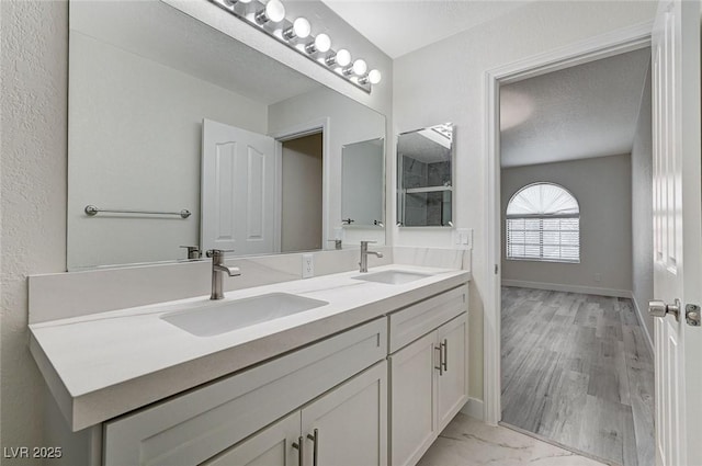 2633 S Durango Dr Unit 201, Las Vegas, NV 89117 - full bathroom featuring double vanity, marble look tile flooring, a shower, and baseboards