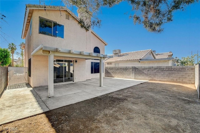 back of property with stucco siding and a fenced backyard