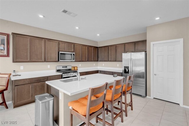 3556 Valley Lily St, North Las Vegas, NV 89032 - kitchen with stainless steel appliances, light tile patterned flooring, a sink, a kitchen island with sink, and recessed lighting