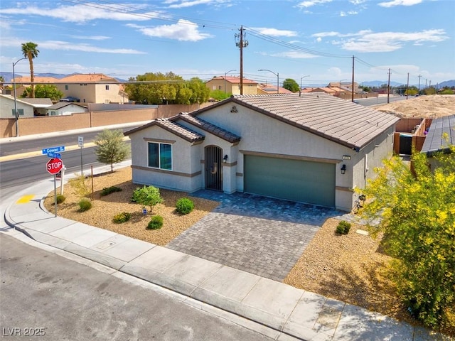 3556 Valley Lily St, North Las Vegas, NV 89032 - view of front of house featuring a tile roof, a garage, stucco siding, and decorative driveway