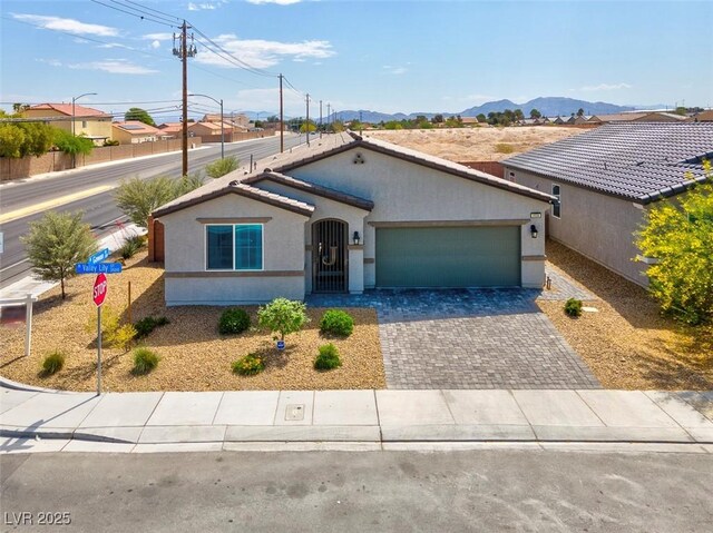 3556 Valley Lily St, North Las Vegas, NV 89032 - view of front facade with stucco siding, a garage, a mountain view, and driveway