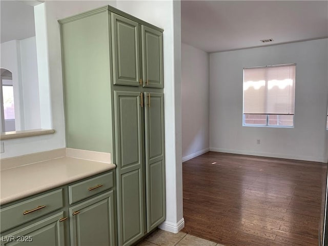 9236 Canalino Dr, Las Vegas, NV 89134 - kitchen with green cabinetry, light countertops, arched walkways, and baseboards