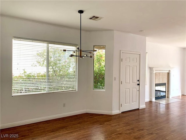 9236 Canalino Dr, Las Vegas, NV 89134 - unfurnished dining area featuring a chandelier, dark wood-type flooring, baseboards, and a tile fireplace