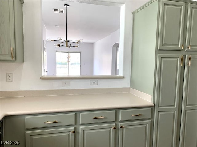 9236 Canalino Dr, Las Vegas, NV 89134 - kitchen with green cabinets, light countertops, and a chandelier